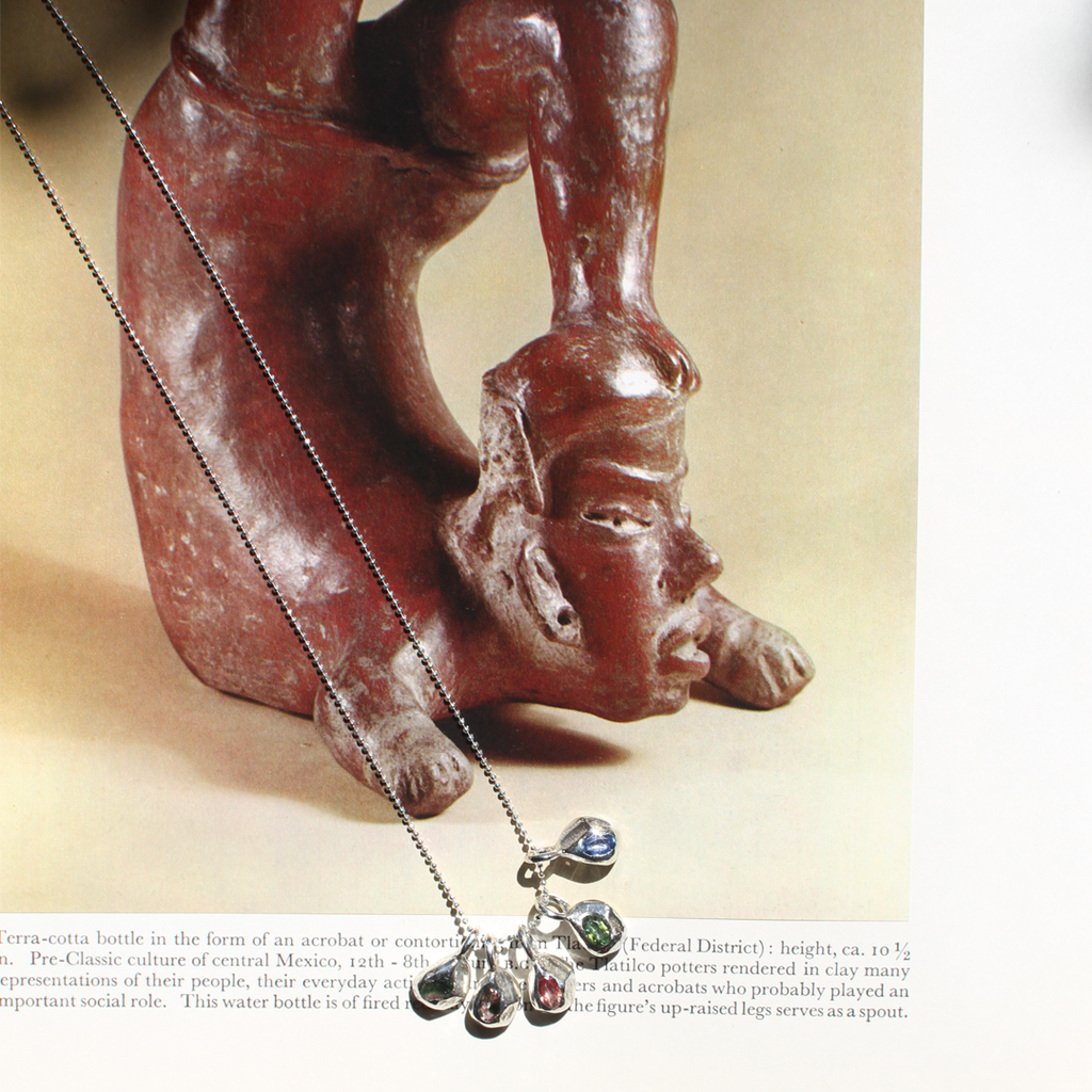 Ceramic figure of a seated figure with a pig, likely from pre-Columbian Central America, on a beige background.